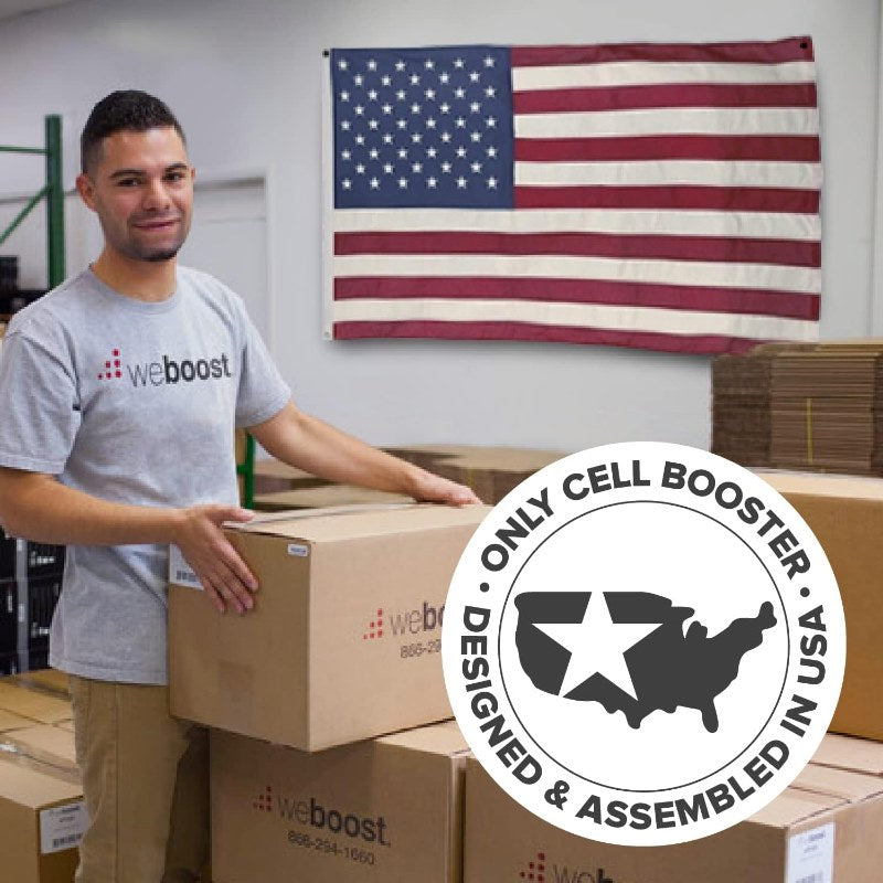 Drive Reach RV lifestyle photo showing a weBoost employee holding a packaging box. There is text to the right of him saying "Only cell booster designed and assembled in USA"