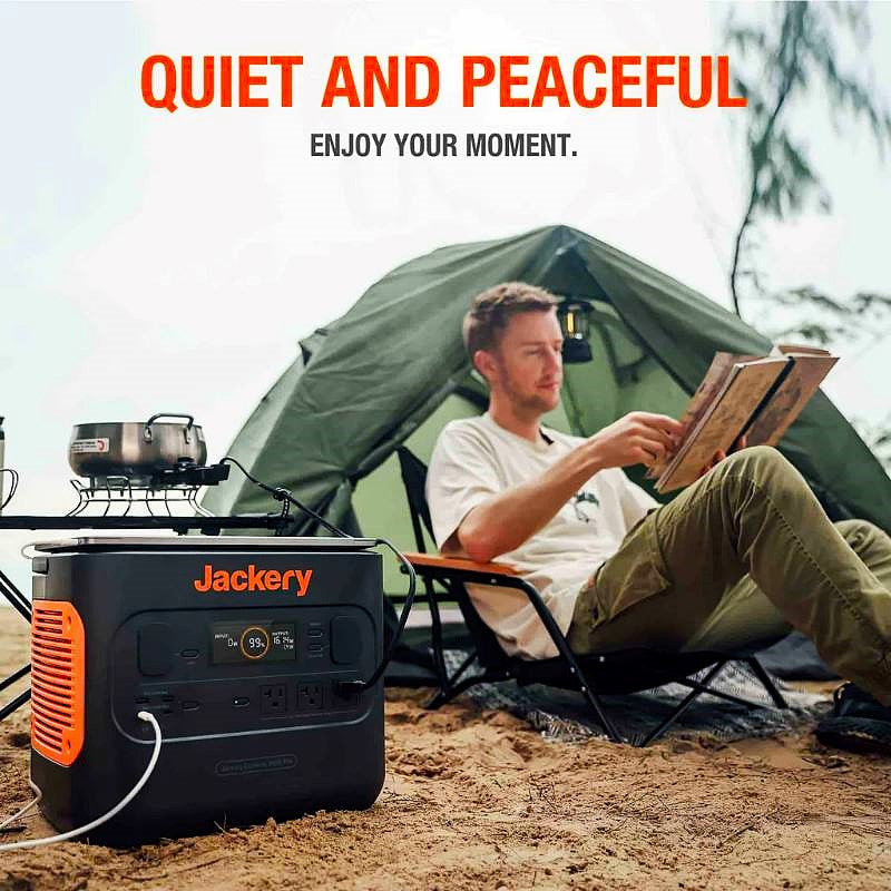 jackery 2000 pro for sale lifestyle image showing a person sitting outside a tent reading a book