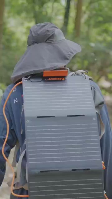 Best 300w Portable Power Station Jackery video showing man walking out on camping trail taking pictures of things with his phone, and he uses the solar generator to hook up and charge his camera, cell phone, and other electronics. 